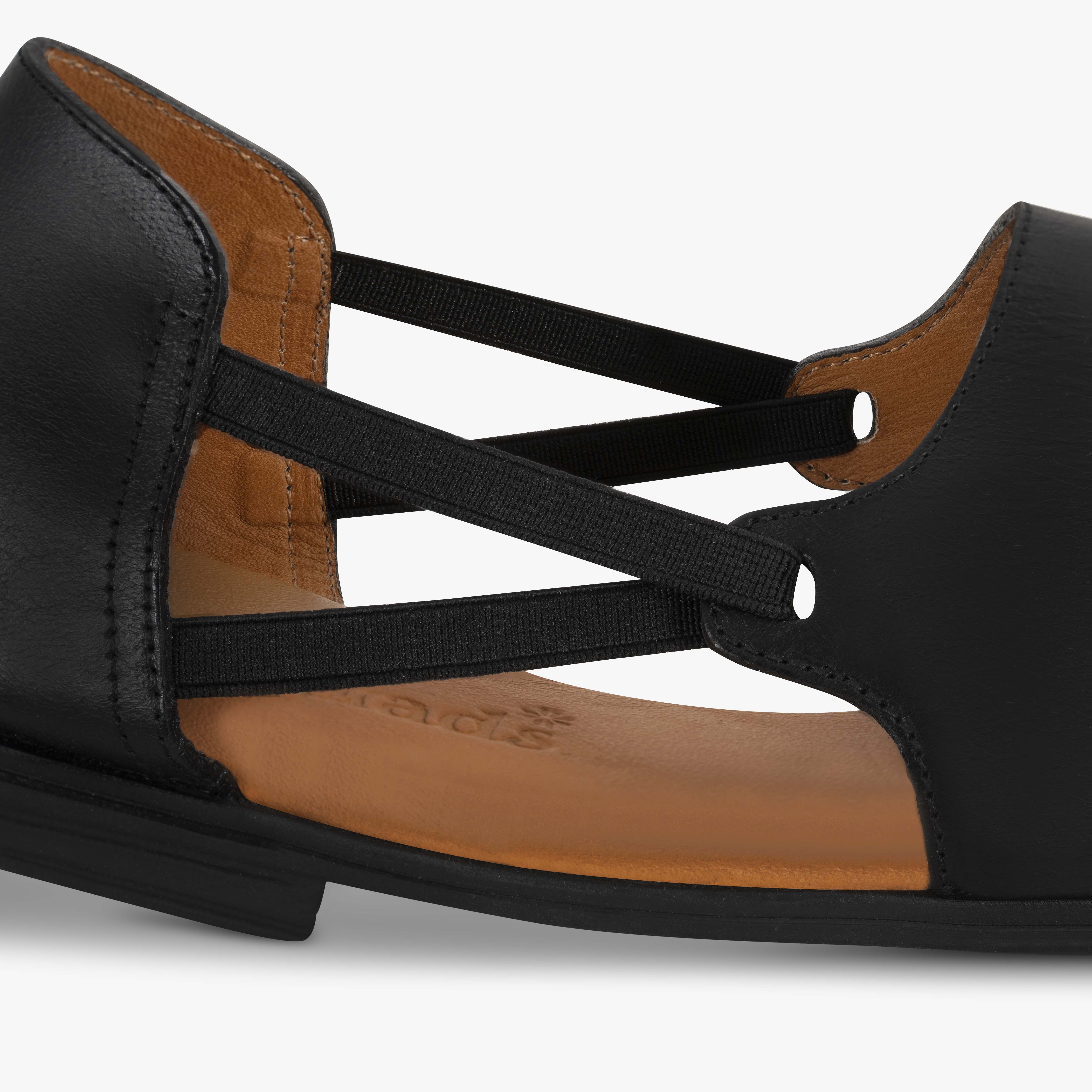 Black sandal with brown insole on a light gray background