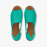 Pair of turquoise shoes with brown soles on a white background