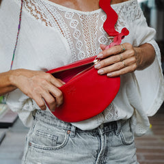 Close up of woman opening red crossbody bag