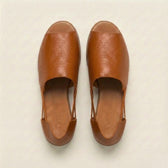 Pair of brown leather shoes on a light beige background