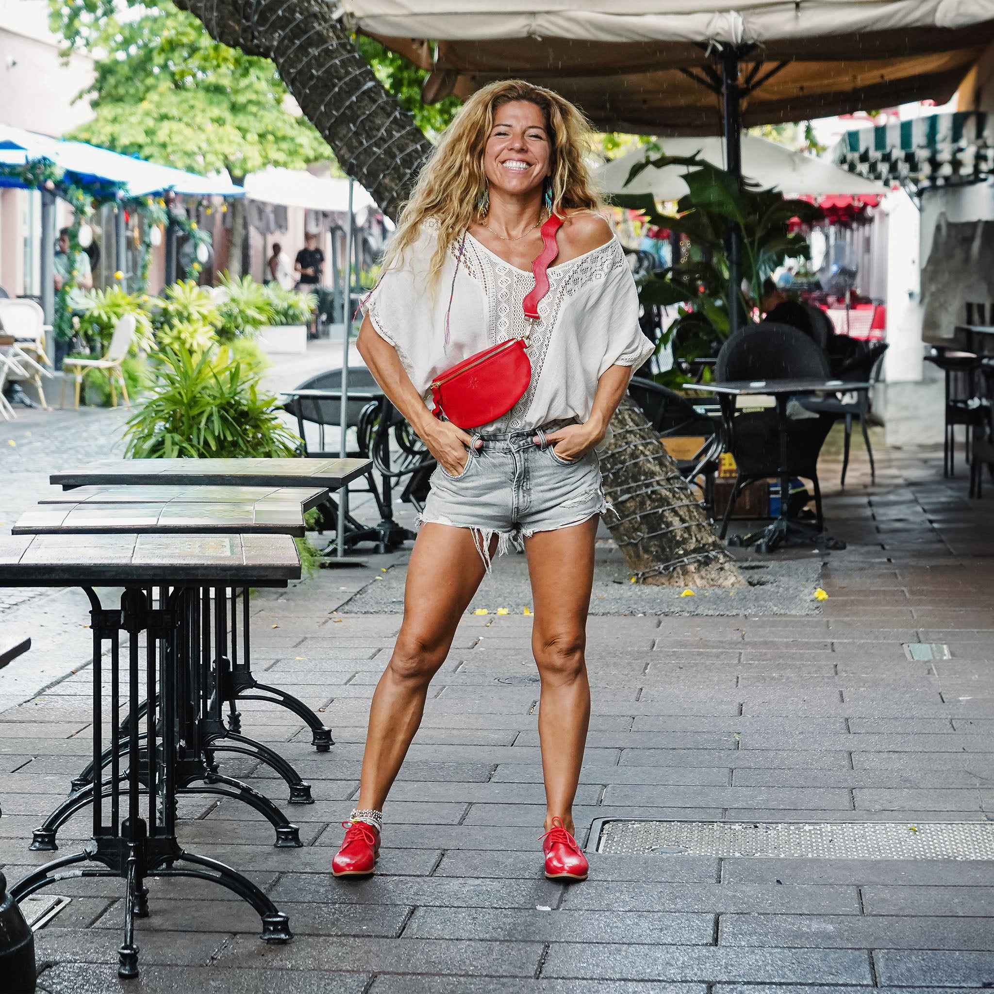 Happy woman wearing red crossbody in Miami streets