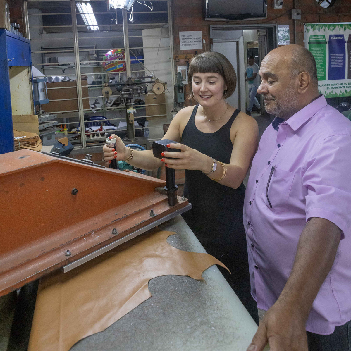 Lisa working a leather press in the Medellín atelier