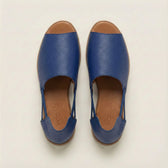 Pair of blue sandals with brown soles on a white background