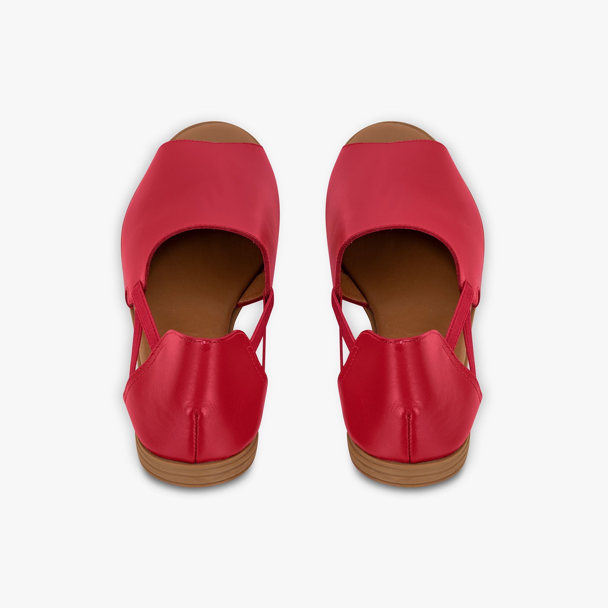 Pair of red sandals with brown soles on a white background
