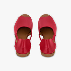 Pair of red sandals with brown soles on a white background