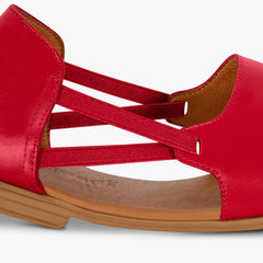 Red sandal with multiple straps on a light gray background