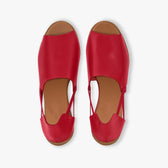 Pair of red sandals with brown soles on a white background