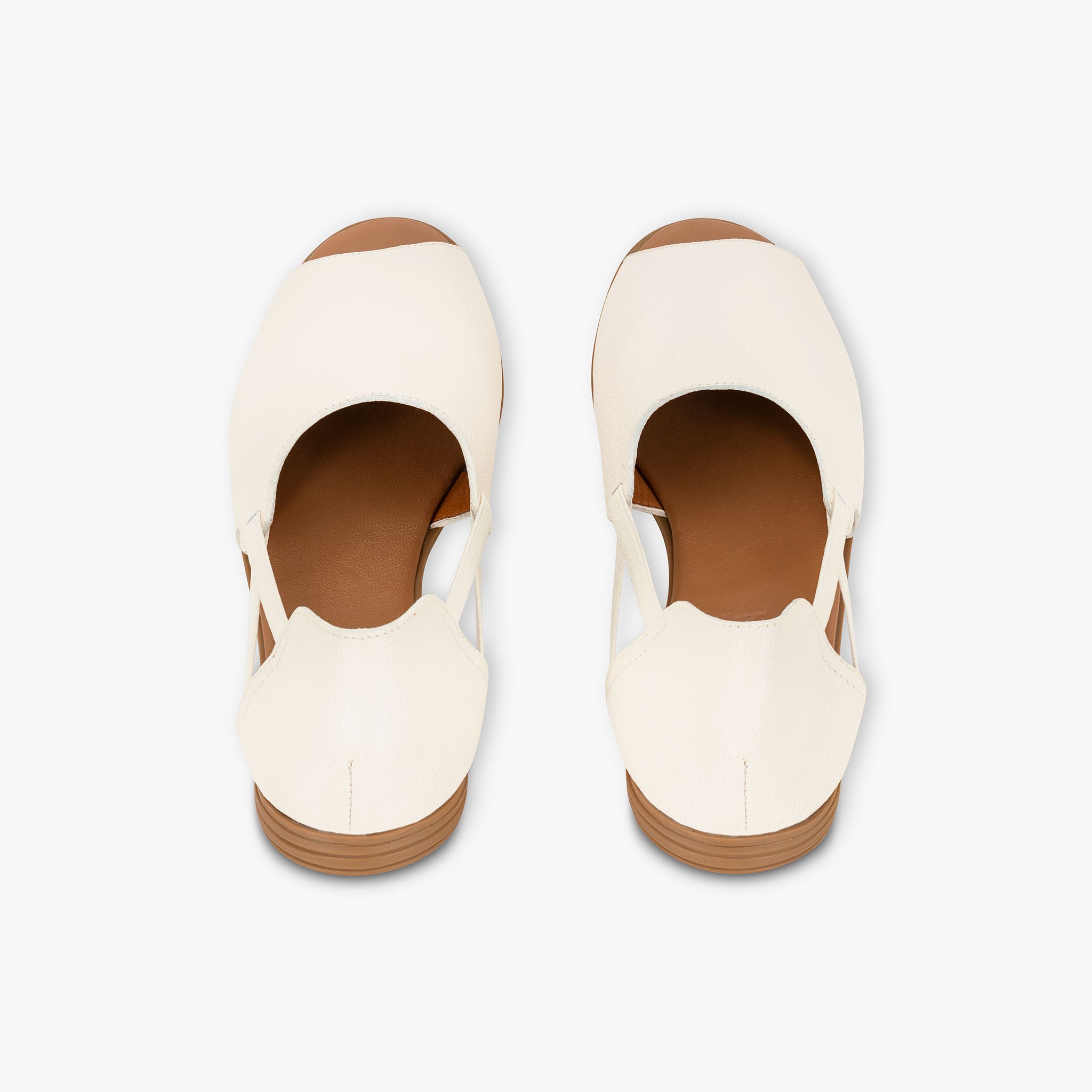 Pair of white shoes with brown soles on a light gray background