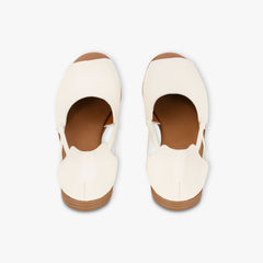 Pair of white shoes with brown soles on a light gray background