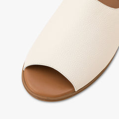 Close-up of a white sandal with a brown sole on a white background