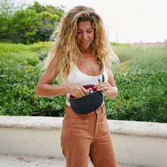 Woman looking into her black leather crossbody bag