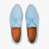 Pair of light blue shoes with brown soles on a white background