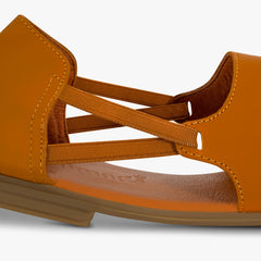Close up of brown sandal with multiple straps on a white background