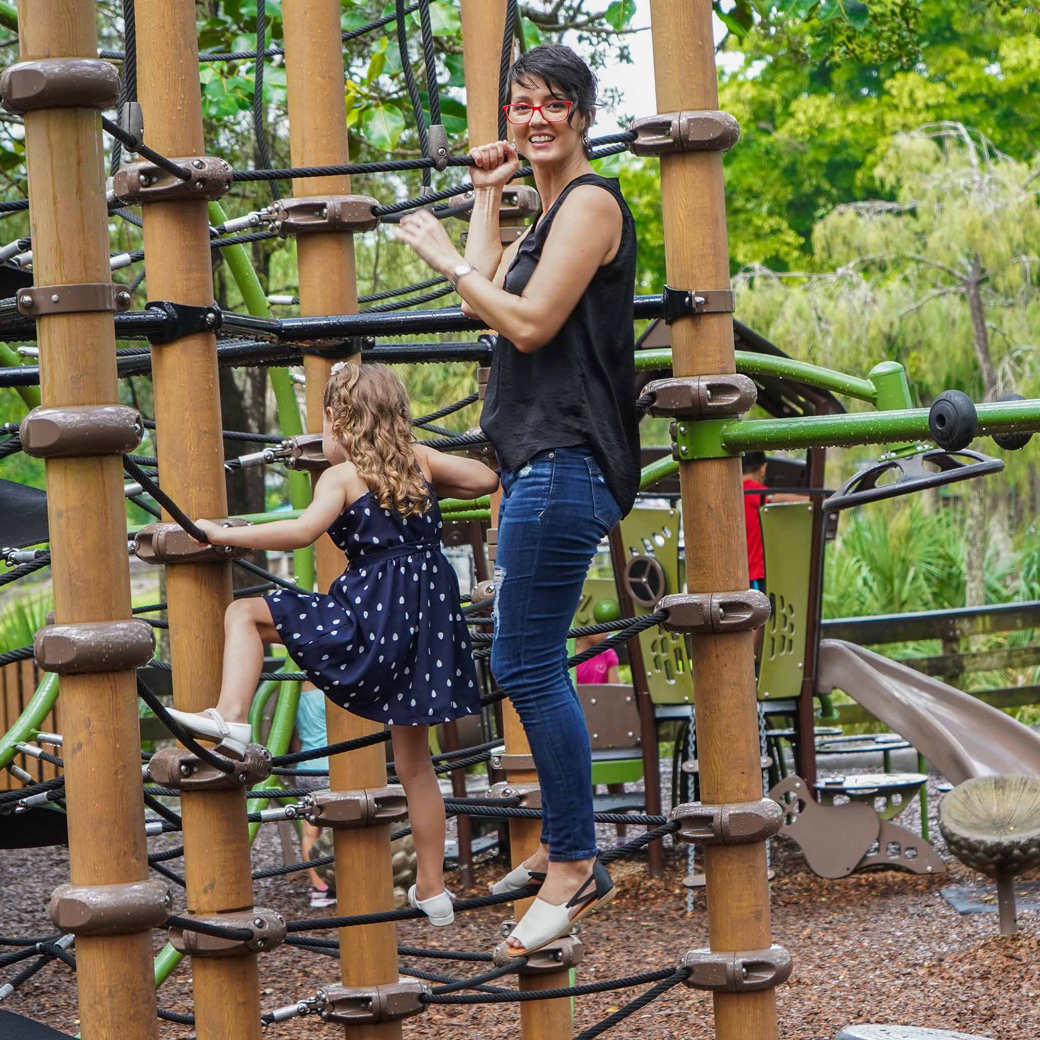 mom wearing black and white Womads with daughter playing at park