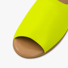 Neon green sandal with brown sole on a light gray background