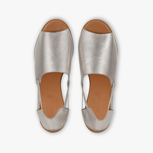 Pair of silver sandals with brown soles on a white background