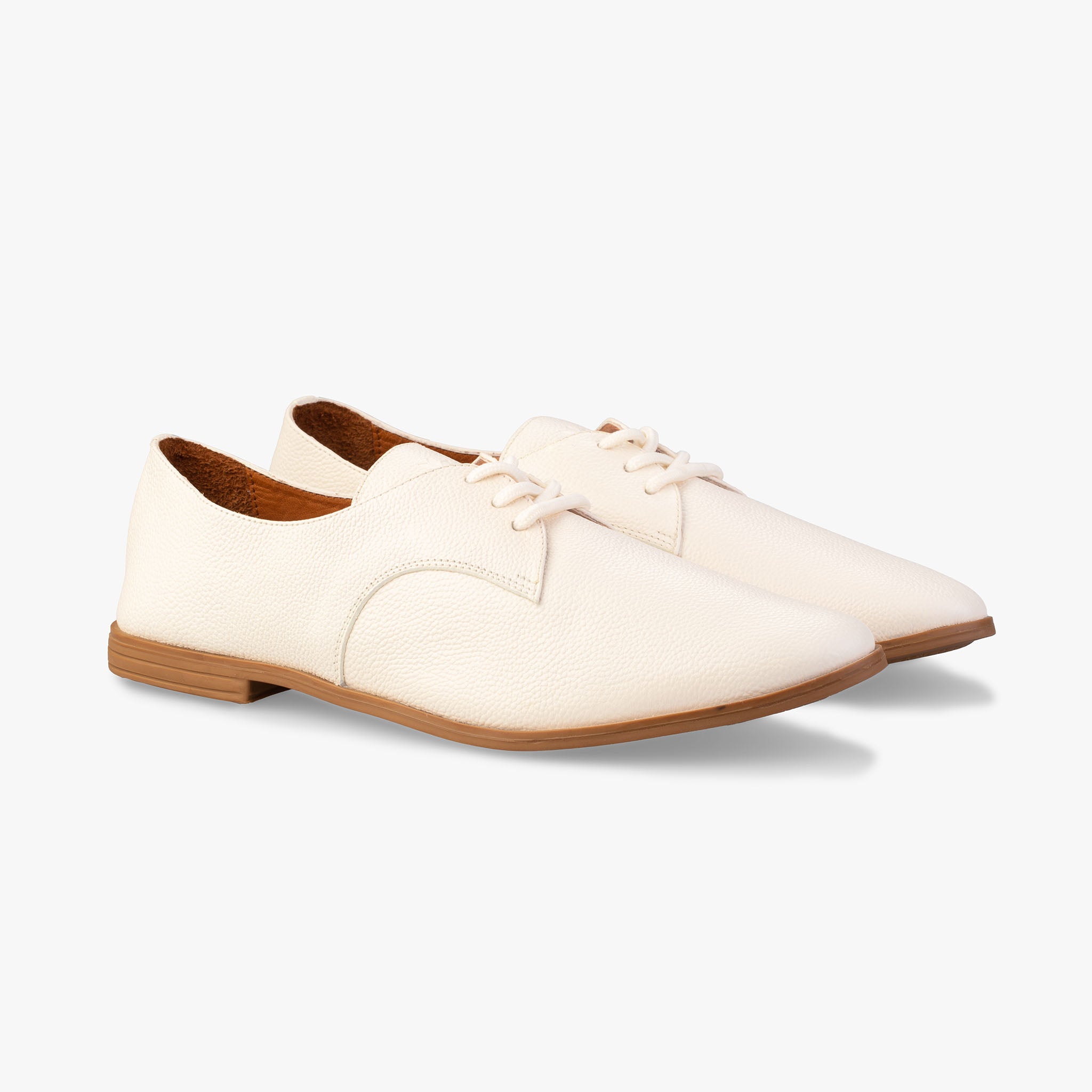 White leather shoes with brown soles on a white background