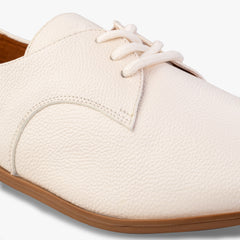 Close-up of a white shoe with brown sole on a white background