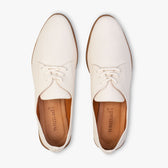 Pair of white shoes with brown soles on a white background