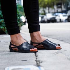 Close up of Womads black sandals worn on street