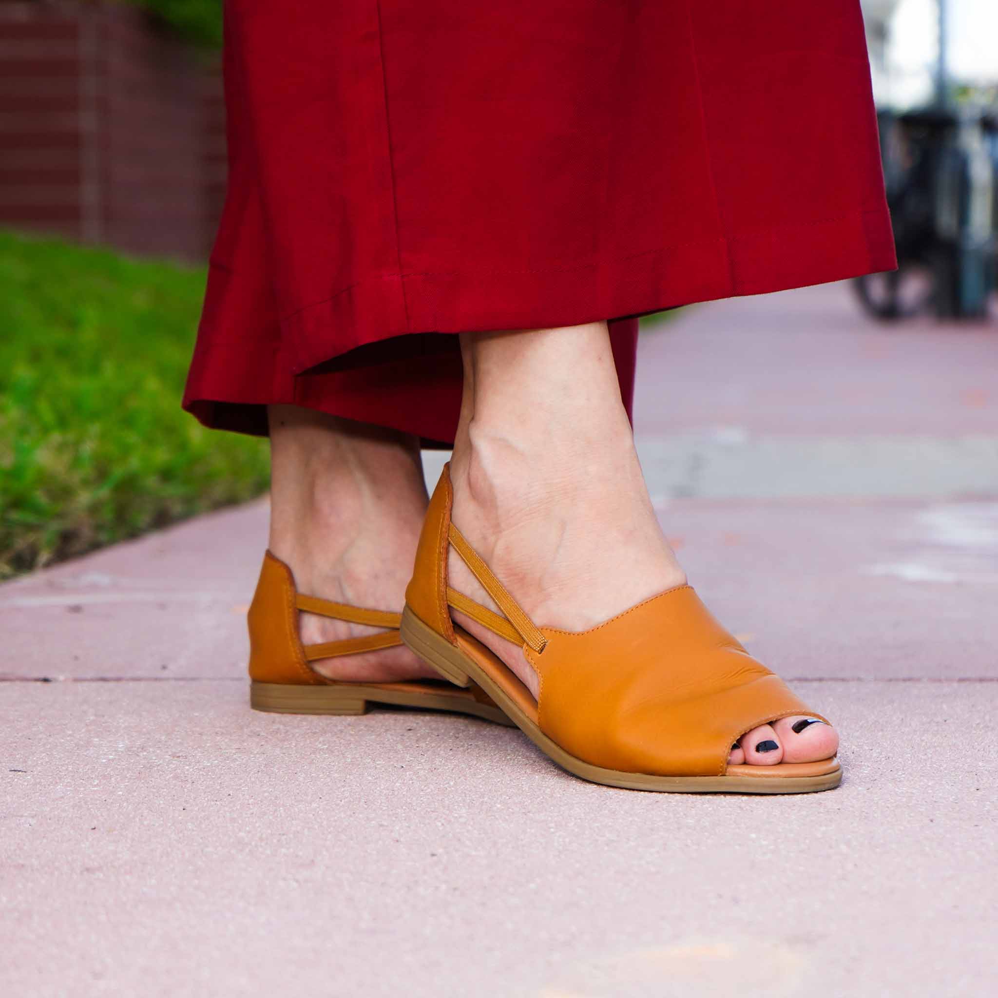 Close up of woman wearing Womads tan sandals in the street