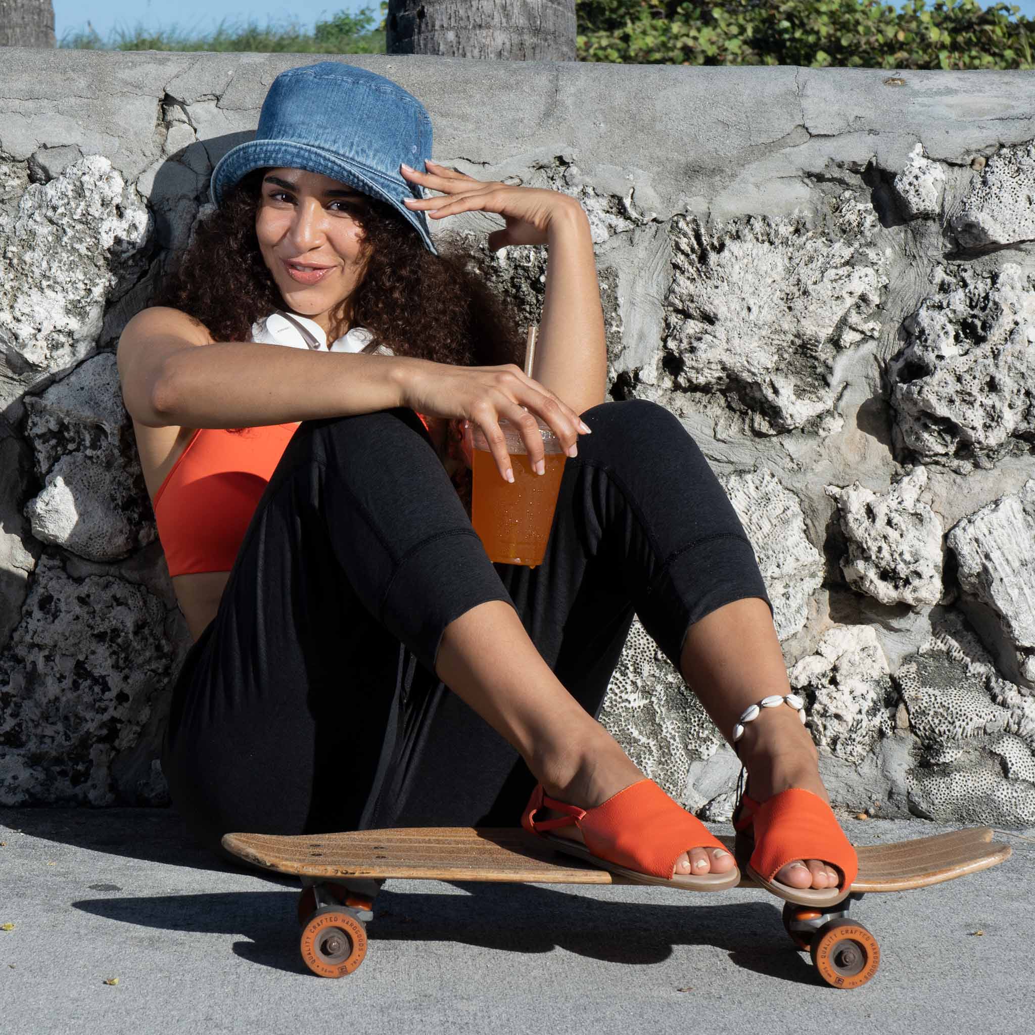 Woman wearing her orange Womads while skateboarding