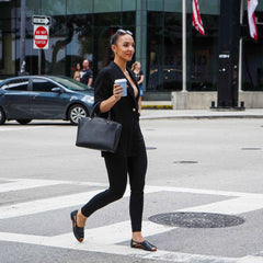 Happy woman in work outfit wearing Womads black flats 